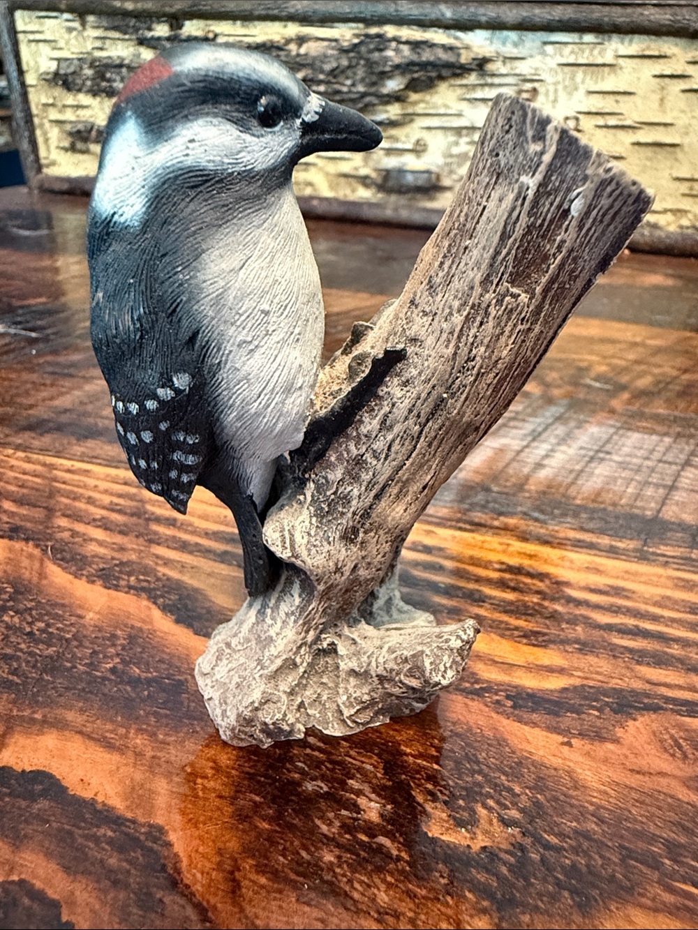 Downy woodpecker on branch figurine